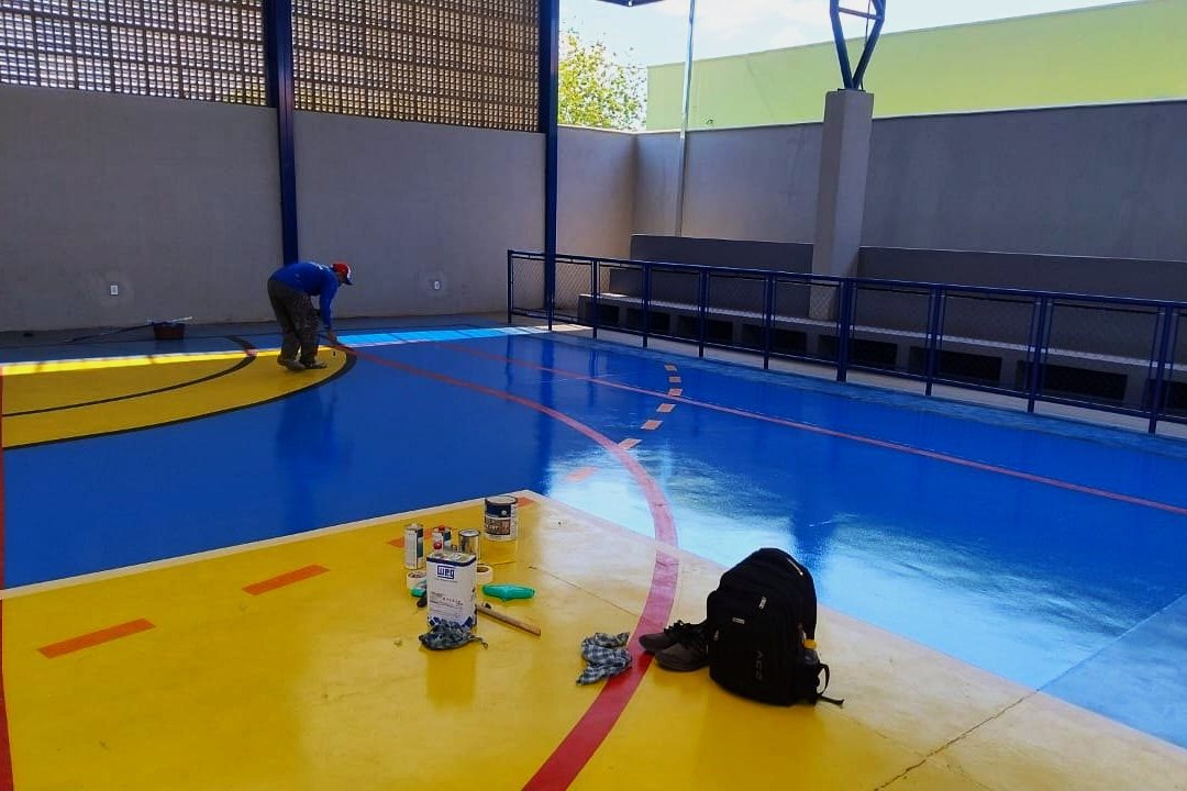 Quadra esportiva com piso epóxi azul e amarelo na Escola Estadual de Dois Córregos